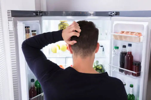 Symbolbild für Emotionales Essen - Mann vor dem Kühlschrank - Auflösende Hypnose in Norderstedt