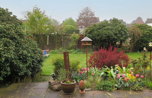 Der Garten teilt sich in seine zwei Ebenen, eine schmale Treppe führt von der Terrasse in den Garten 