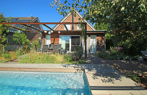 Kleiner Garten mit Pool und Pergola über der Terrasse am Haus