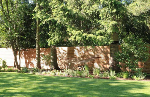 Altbestand an Bäumen dient als Befestigung für die Hängematte, begrenzt wird das Grundstück durch einen neuen Holzzaun