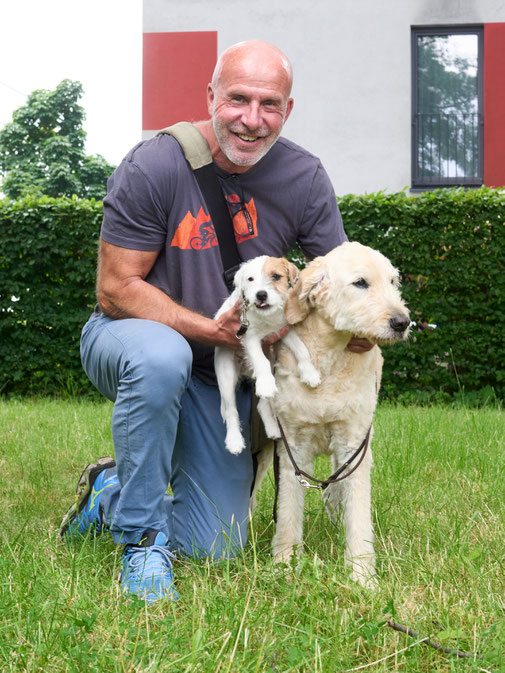 Carsten Offt hält Hund Lille im Arm, daneben Therapiehund Kalle
