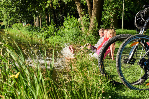 Radfahrer halten die Füße ins Wasser am See