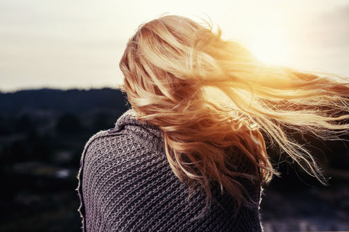 Girl with blond glowing hair at sunset