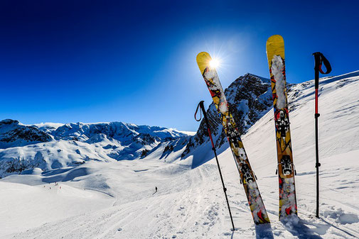 Skier im Schnee beim Wintersport in den Bergen, Skifahren mit der Ski- und Snowboardversicherung