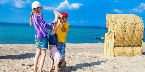 Kinder spielen am Strand und machen akrobatische Übungen
