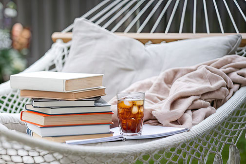 Hängematte mit Kissen, Büchern und einem Drink als Synonym für die ERGO Jahresversicherung