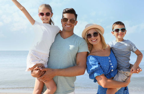Familie am Strand mit Sonnenbrillen