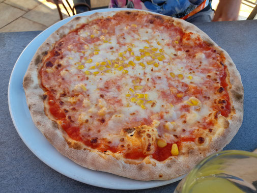 Eine Pizza belegt mit Käse und Mais