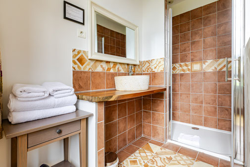 salle de bain rénovée avec douche et matériaux authentiques dans une chambre du château de Loubéjac