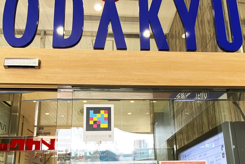 新宿西口ハルクの入口ガラス扉にナビレンスコードが貼ってある。コードの上にはODAKYUの文字が見えている