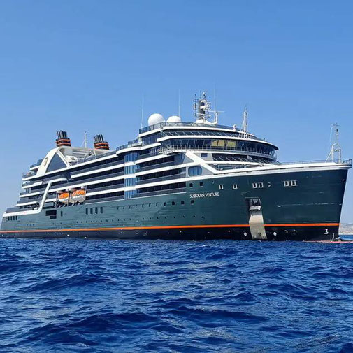 Großes luxuriöses Expeditionskreuzfahrtschiff Seabourn Venture fährt auf offenem blauen Meer unter klarem Himmel, vom Meeresspiegel aus fotografiert.