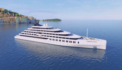 Emerald Kaia Yacht liegt ruhig auf dem Meer. Im Hintergrund befindet sich eine Küstenstadt mit farbenfrohen Gebäuden.