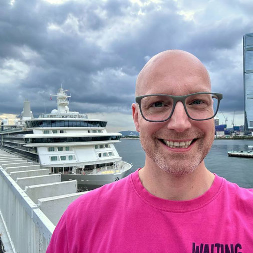 Timo Clarén von Emocean Cruises im Hafen von Hongkong, im Hintergrund das Luxusschiff Silver Nova von Silversea