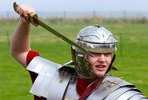Reconstitution d'un légionnaire romain en armure tenant un glaive.