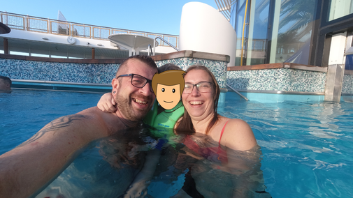Mama, Papa und Kind schwimmen in einem Pool auf einem Kreuzfahrtschiff.