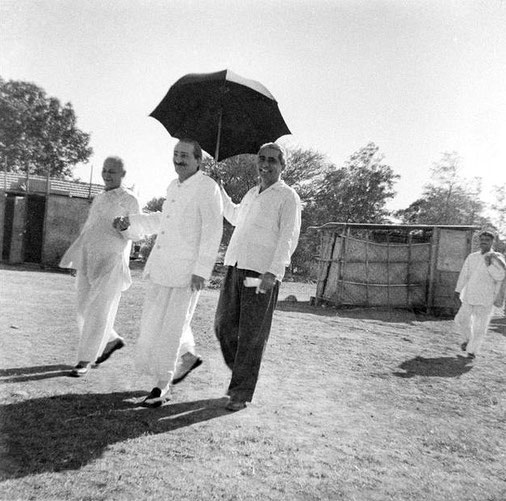 Baba holding Gustadji's hand, Adi K holding umbrella with Eruch following