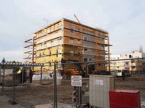 写真3 木造の集合住宅 CLTの構造体、下から断熱材を施工中。階段室は鉄筋コンクリート