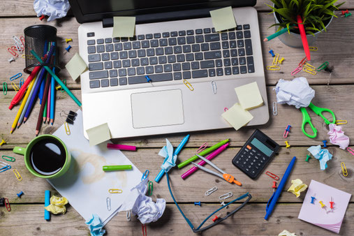 Unordentlicher Arbeitsplatz mit Laptop