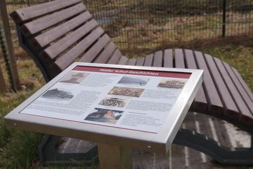 Im Vordergrund eine Infotafel, im Hintergrund eine Wellenbank.