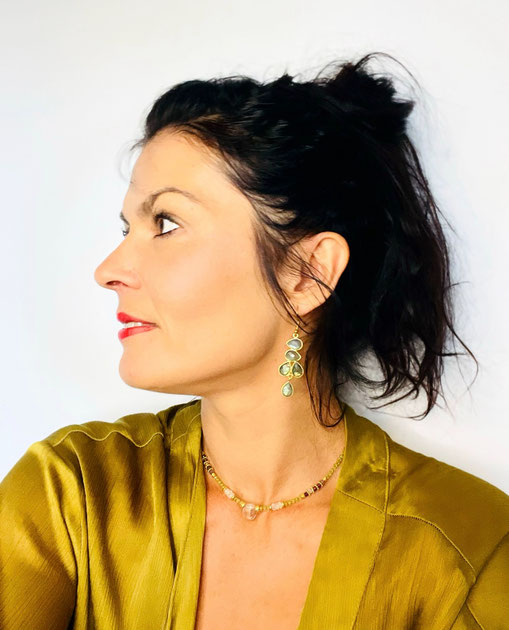 Portrait de NINE, artiste à Trans en Provence, portant des bijoux artisanaux en pierres naturelles: labradorite, cristal roche et péridot. Des créations françaises faites à la main, choisies avec soin pour leur énergie et leur esthétique.