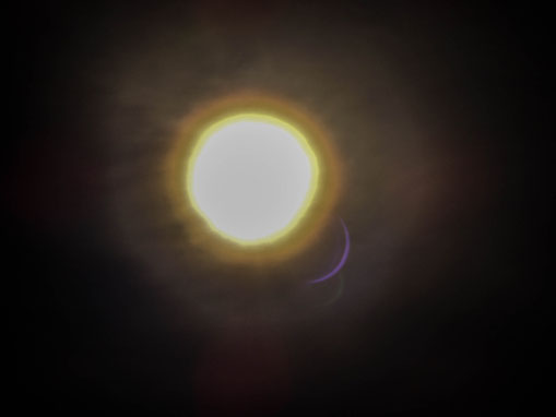 An almost complete solar eclipse. Only the small sliced reflection (to the right) shows the correct sun by moon covering. // Eine fast vollständige Sonnenfinsteris. Die sichelförmige Reflexion (unten rechts) zeigt die wahre Sonne durch Mond Verdeckung.