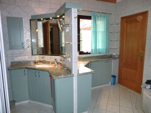 Modernes Bad mit Whirlpoolbadewanne, Dusche, Doppelwaschbecken, WC und Bidet.