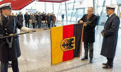 Ministerpräsident Erwin Sellering nimmt die Ehrung mit Fregattenkapitän Christian Meyer (r.) vor, Fahnenträger ist Oberbootsmann Mario Ackermann. Foto: Georg Scharnweber