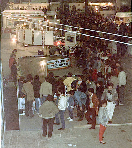 La foule autour de la piste de slot racing pendant que des amateurs la testent.