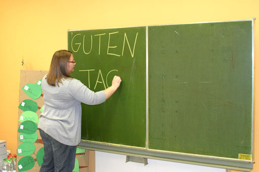 Lehrerin schreibt Guten Tag an Tafel