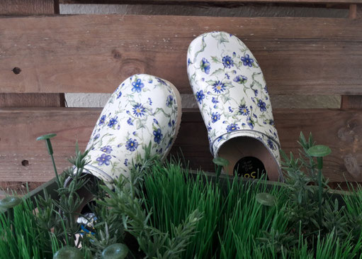 Weiße Clogs aus Holz mit blauen Blumen