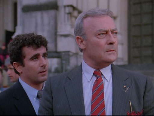 Edward Woodward as Robert McCall in The Equalizer accomplishes the mission but the woman gets away, as Jason, played by Saul Rubinek, tells him to get away from the scene of the attempted assassination in the first season episode "A Distant Fire"