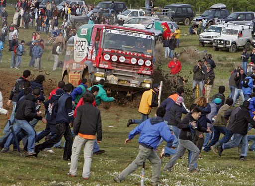 Spectators run away from Spain's driver Fernando Vila Roca sliding his Iveco at Almodovar on Southern Portugal during the 1st stage of the Lisbon-Dakar rally December 31, 2005. 