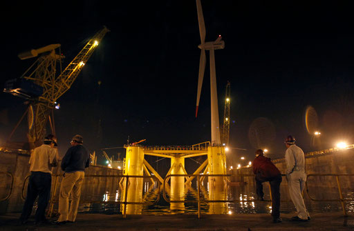 Shipyard workers look at the windmill, Wind Float I, before it is launched to sea in Setubal, 50 km (31 miles) south of Lisbon, September 30, 2011.