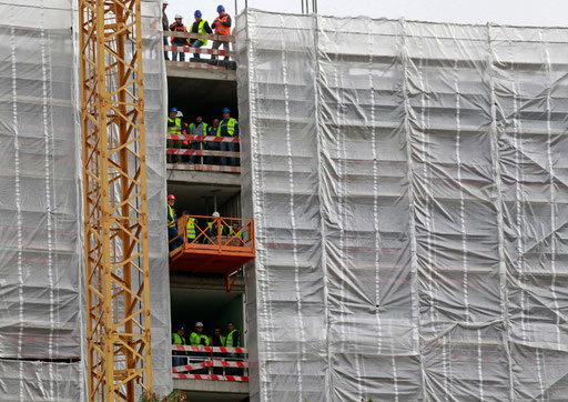 Construction workers pause to watch an event at a Lisbon street on January 2014.