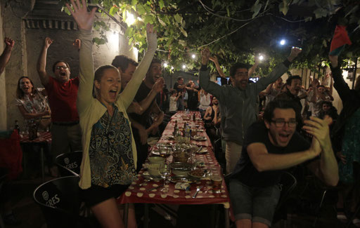 Portugal's national football team supporters react to the goal as they watch a television at a bar in Lisbon on July 10, 2016 the Euro 2016 final football match Portugal vs France 