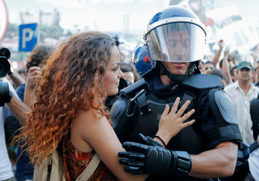 Woman embraces riot policeman in front of of the IMF office in Lisbon protected by riot policemen during a protest against austerity September 15, 2012.