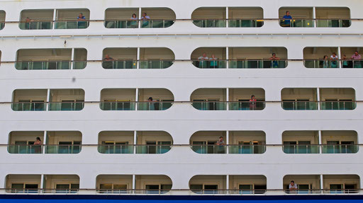 Passengers of a cruise ship watch the city of Lisbon from the balconies of their rooms on 2013
