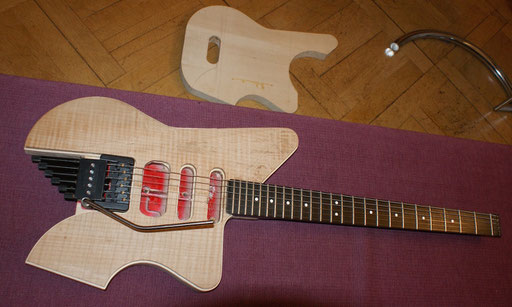 The new body, old neck and modded trem on my sofa. On the floor the lower part of the body-sandwich with the hole to grant access to the trem lock and trem tension spring and screw.