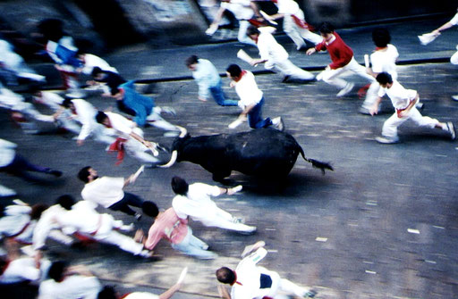 Runners and the first bull out of the gate sprint up the street of Santo Domingo on Day 1 of the Sanfermines.