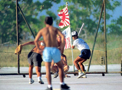 A Japanese Coastguardsman prepares for a mighty swing as his team squares off against their US counterparts in the weekly "transpacific" softball game on the runway at Marcus Island, Japan.