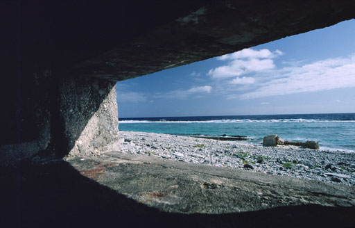 A pillbox's gunport view across the lagoon and coral reef beyond; Marcus Island, Japan.