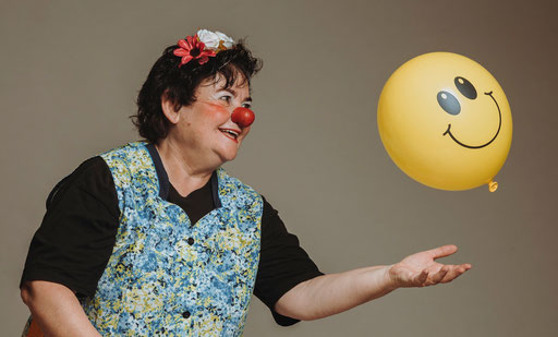 Clownin Olga spielt mit dem Smileyballon
