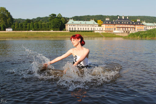 Braut badet in der Elbe im Brautkleid