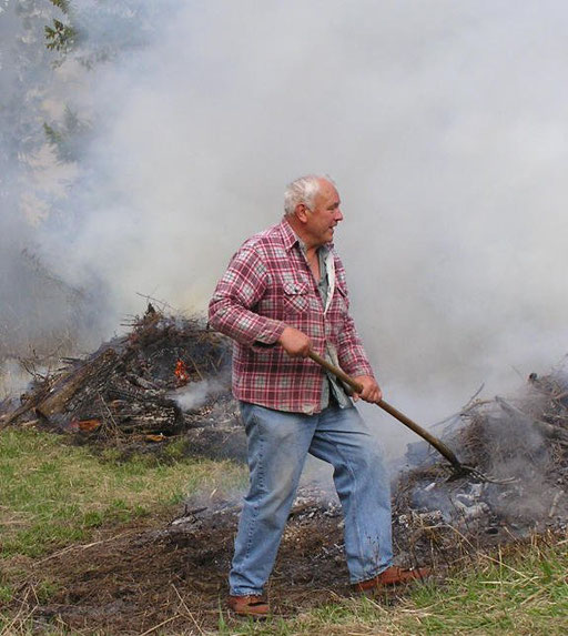 Erv Weiler tending brush pile burning