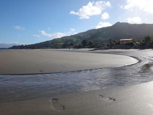 Strand mit Hütten von Pakawau im Hintergrund