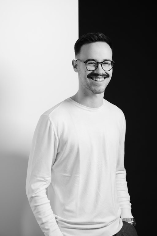 Junger Mann mit Brille und Schnurrbart in Fotostudio Beleuchtung. Professionelles Porträt Foto.