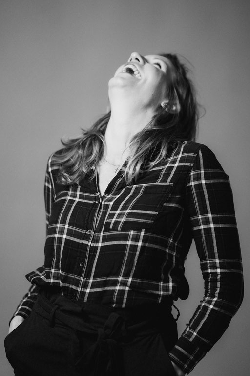 Herzhaft lachende Frau mit kariertem Hemd. Aufgenommen von Sebastian Schieder Porträt Fotograf Regensburg.