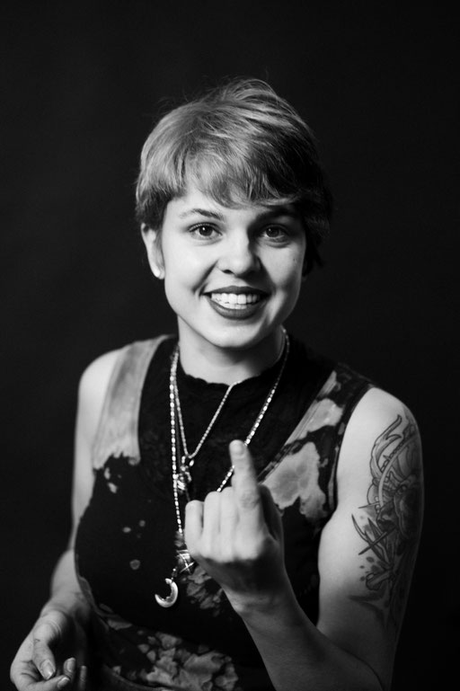 Junge Frau mit erhobenem Zeigefinger. Studio Porträt. Aufgenommen von Sebastian Schieder Porträt Fotograf Regensburg.