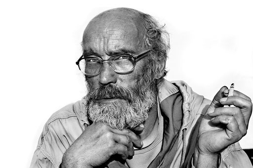 Mann mit Bart und Brille, nachdenklich blickend. Analog aufgenommenes Foto. Aufgenommen von Sebastian Schieder Porträt Fotograf Regensburg.