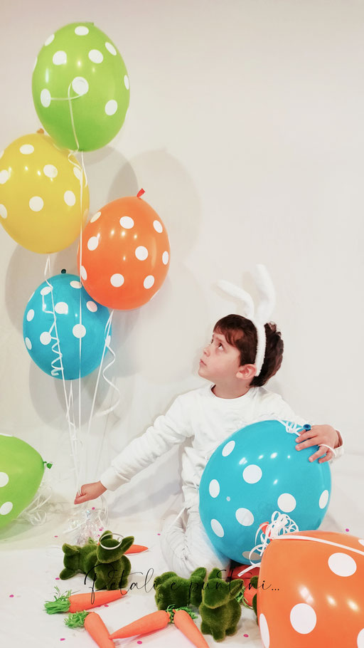 bambino vestito da coniglio di pasqua con palloncini colorati e coniglietti